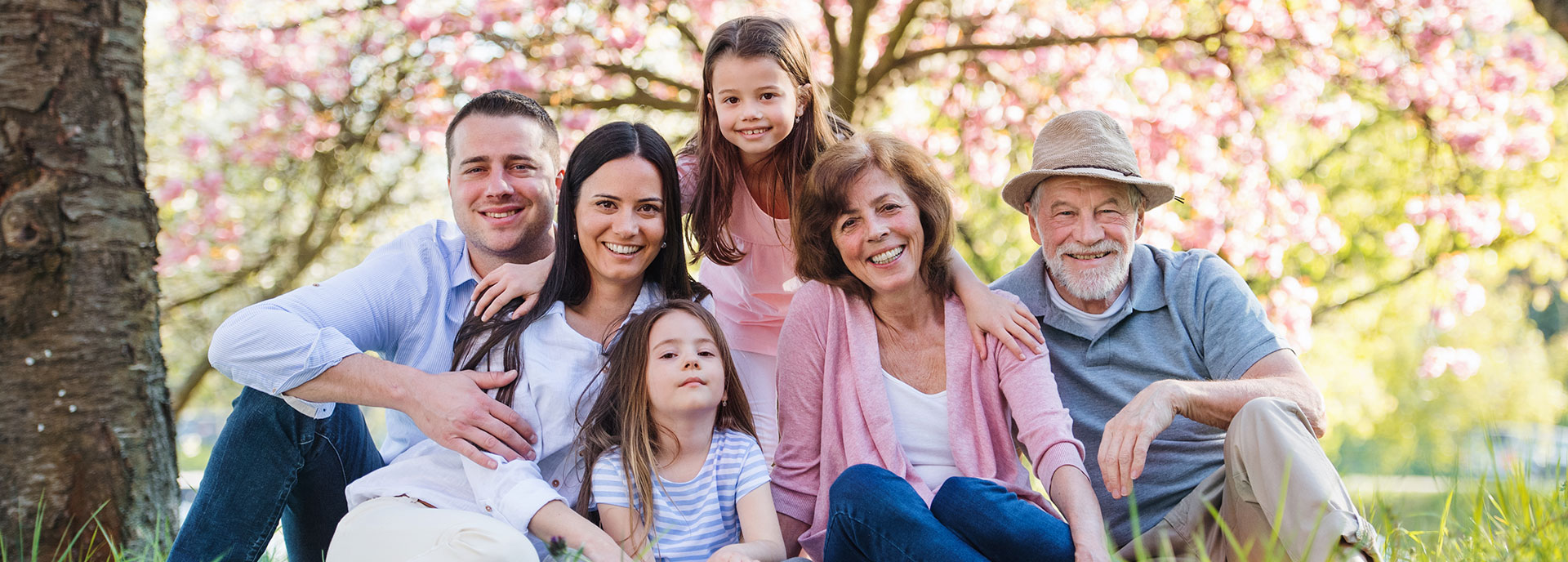 happy healthy multi-generational family taking a photo in a beautiful spring setting
