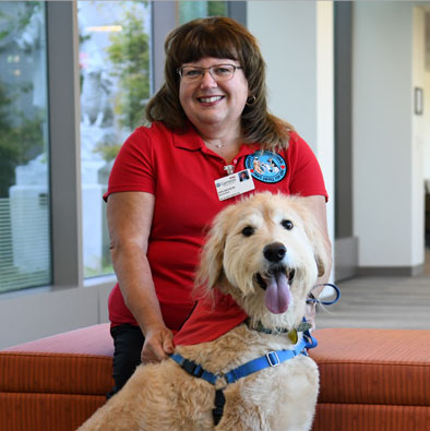Genesis therapy dog, Parker, Goldendoodle breed, with owner Jodi Dickson