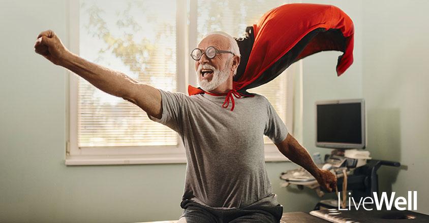 elderly man celebrating with red cape like a superhero