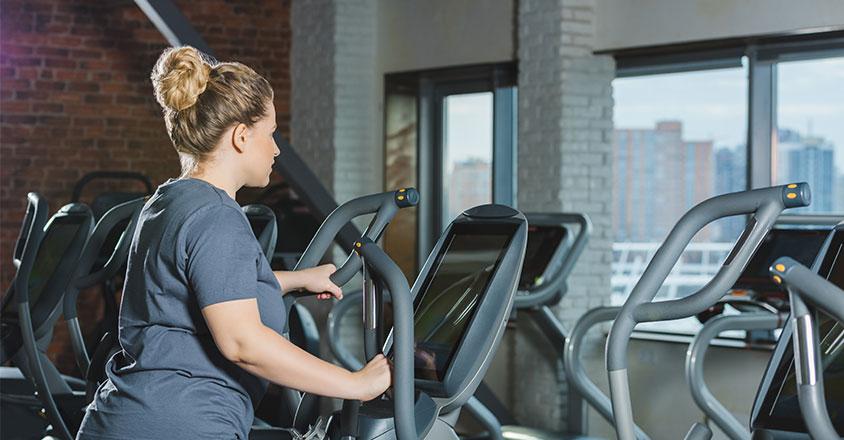woman working out on an elliptical machine