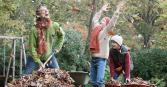 Father raking leaves with sons
