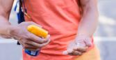 zoom in of man spraying sunscreen on his hand