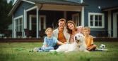 family posing for photo in their front yard with dog, two kids and parents