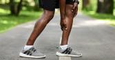 close up of man holding his calf muscle, representing a muscle cramp