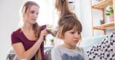 Mom trying to brush out tangles in daughters hair