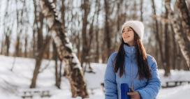 woman standing outside in the winter bundled up and smiling