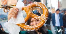 close-up of a large salty pretzel held by a woman 