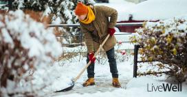 man shoveling snow in the winter