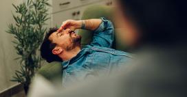 man stressed, holding his hand over his forehead