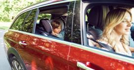 red car, zoomed in on the passenger side from outside, mom in passenger seat, and young daughter in backseat in a carseat 