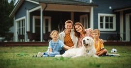 family posing for photo in their front yard with dog, two kids and parents