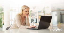 woman on her laptop, smiling in a kitchen at home