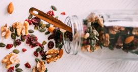 trail mix spilled over on counter with mason jar and spoon
