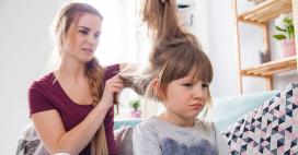 Mom trying to brush out tangles in daughters hair