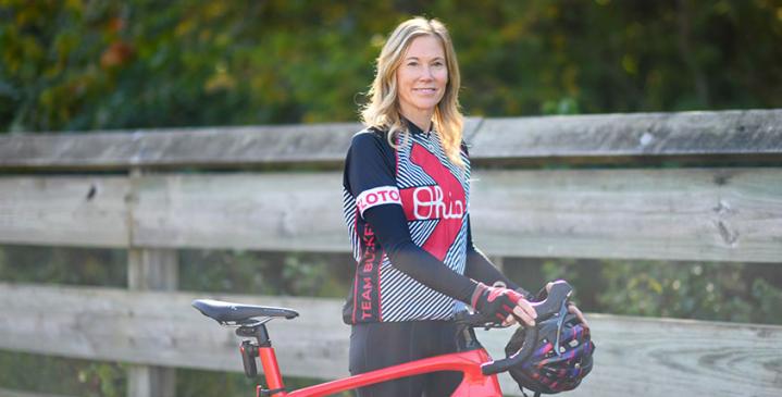 Genesis patient posing for photo next to red bike smiling